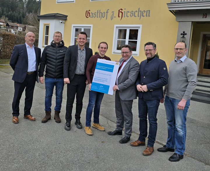 Bayerns Wirtschaftsstaatssekretär Tobias Gotthardt hat das Hotel zum Hirschen in Lam besucht und der Betreiberfamilie Sperl-Vogl eine Förderurkunde für das neue Biomasseheizwerk überreicht. Das Foto zeigt (v.l.n.r): Unternehmensberater Klaus Etzold, Steuerberater Philipp Weininger, MdL Julian Preidl, Hotelbetreiber Andreas Vogl, Staatssekretär Gotthardt, MdL Gerhard Hopp und Energieberater Wolfgang Kuchler. Foto: StMWi