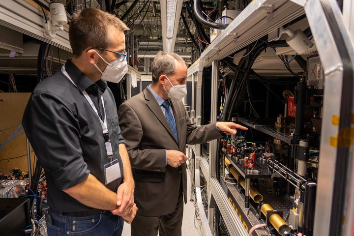 Dr. Sebastian Blatt (Leiter am MPQ) erklärt Staatsminister Hubert Aiwanger im Ultracold Strontium-Labor (Max-Planck-Institut für Quantenoptik[MPQ]) einen Quantensimulator. (Fotonachweis: StMWi / E. Neureuther)