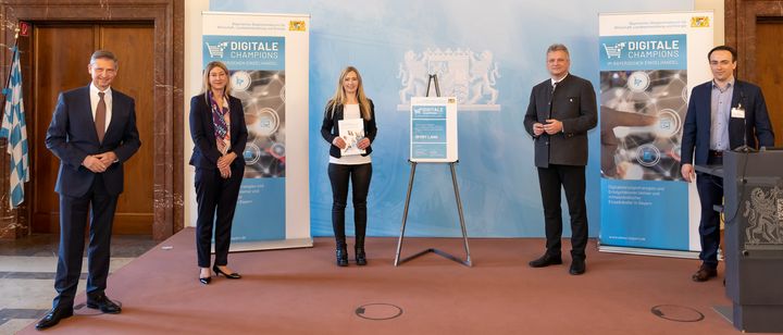 Sport Lang mit Sitz in Vohenstrauß ist „Digitaler Champion im bayerischen Einzelhandel 2021“ (v.l.): Wolfgang Puff (Hauptgeschäftsführer Handelsverband Bayern e.V.), Simone Wastl (Leitung Unternehmenskommunikation und Marke, Mitglied der Geschäftsführung DATEV eG), Juliane Lang (Junior-Chefin Sport Lang), Wirtschaftsstaatssekretär Roland Weigert und Dr. Johannes Faltermeier (Projektleiter ibi research an der Universität Regensburg GmbH). Foto: Elke Neureuther/StMWi